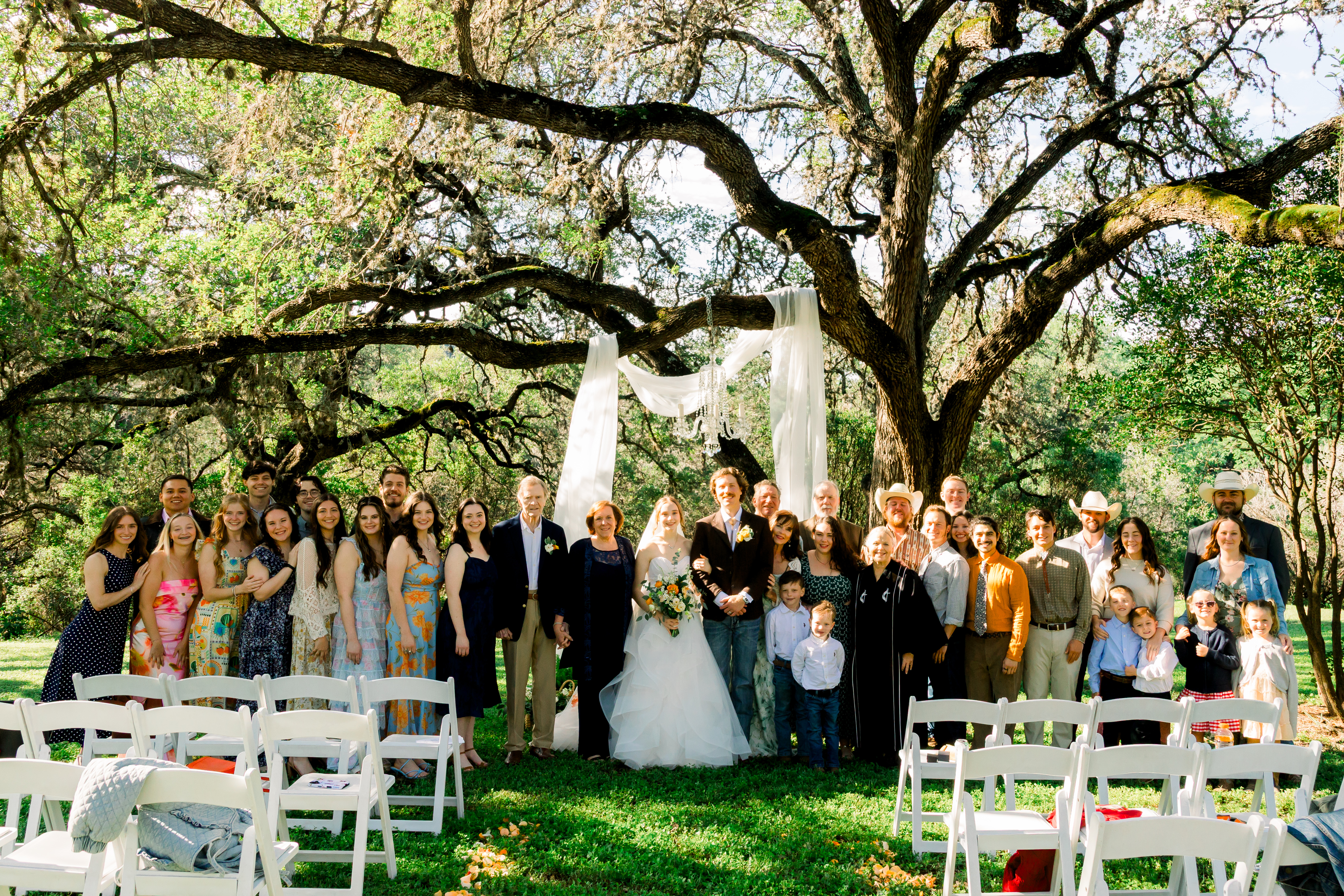 The wedding party and family gathered under the oak