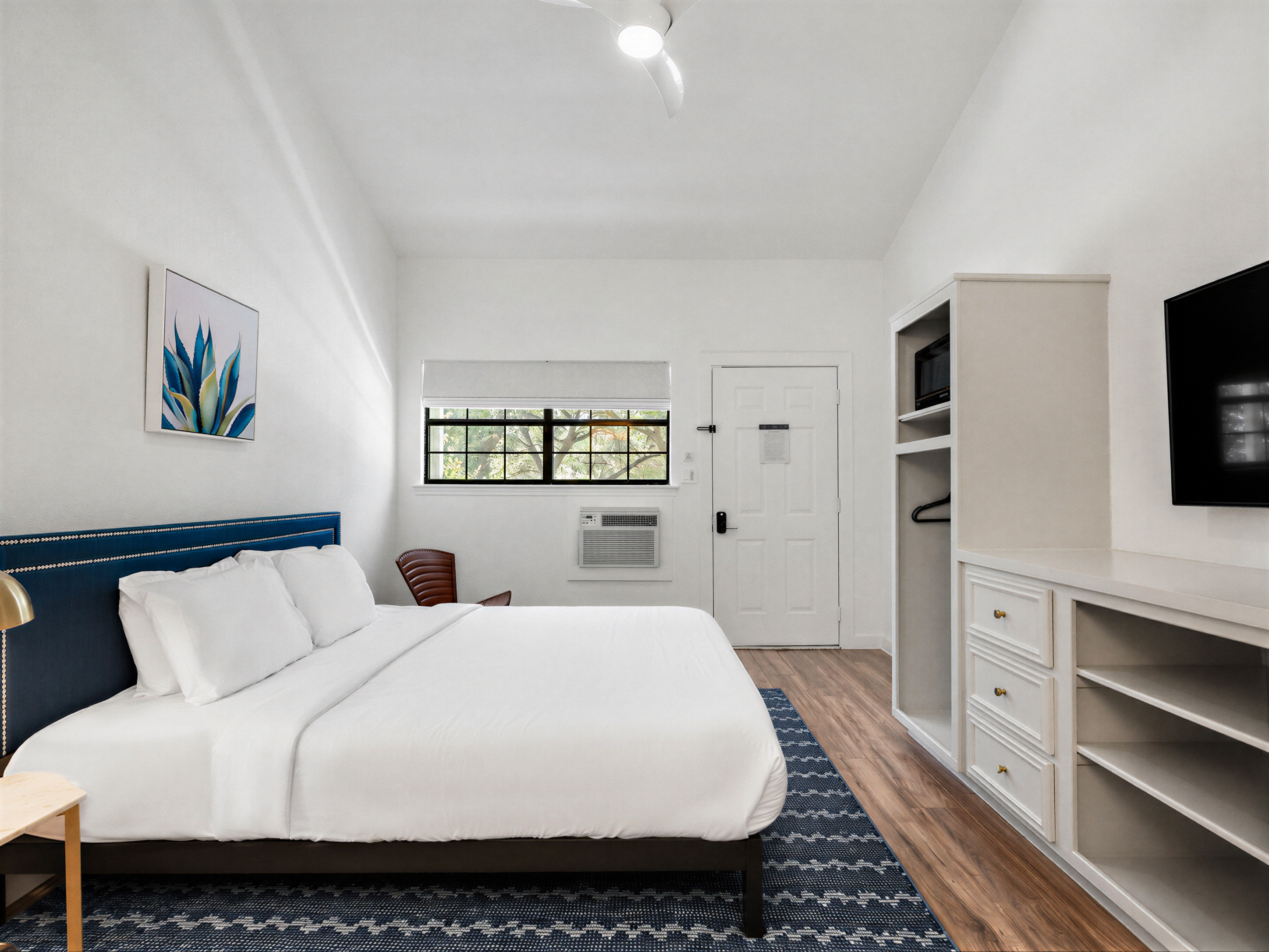 Deluxe King room with a navy headboard and a view into the vanity