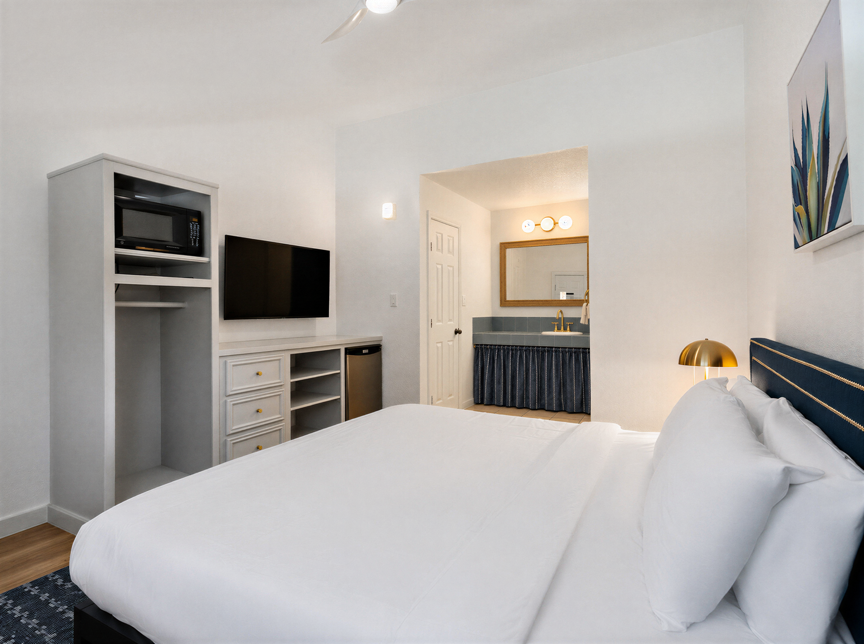 Deluxe King room with a navy headboard and a view into the vanity