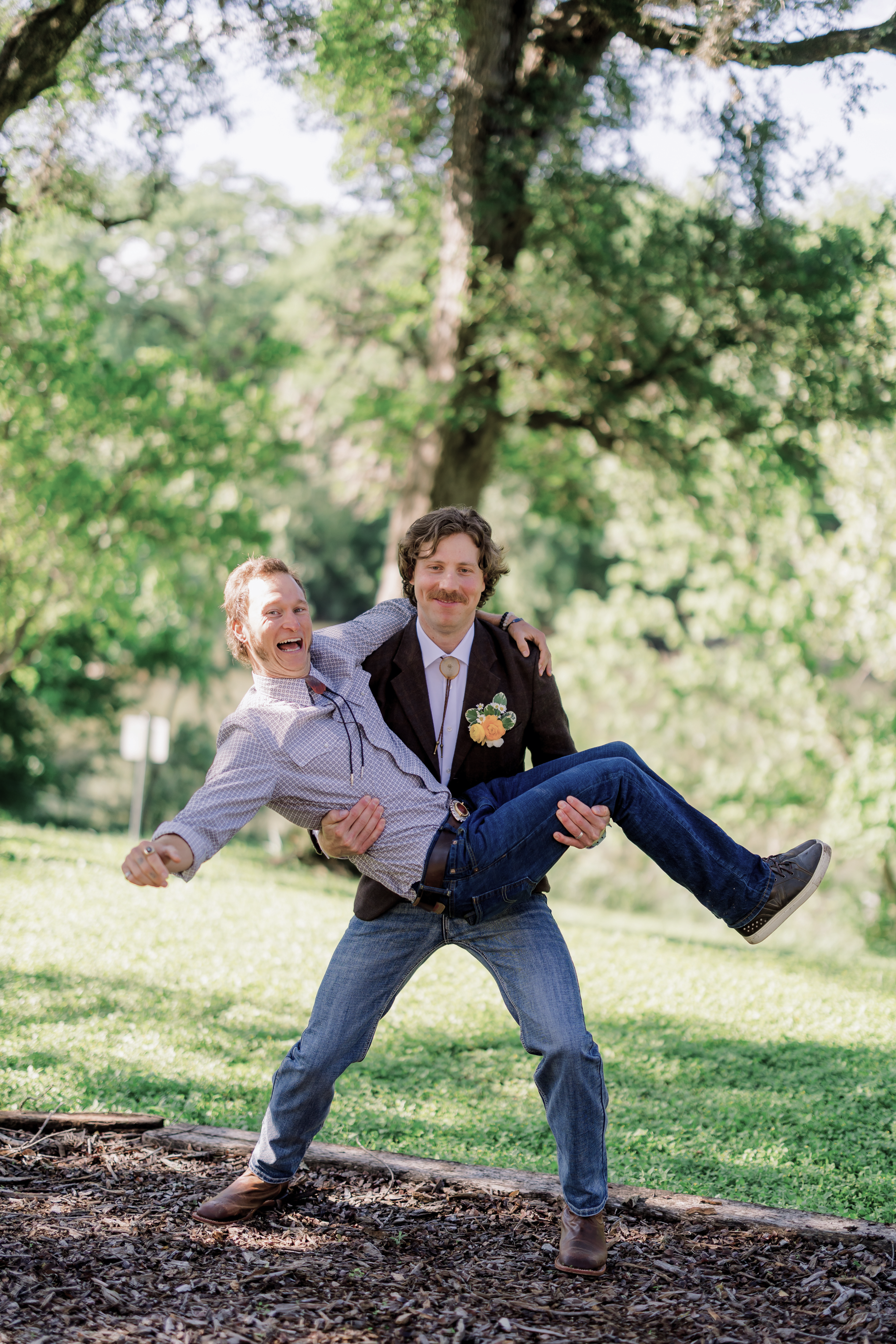 The groom carrying a friend on the lawn