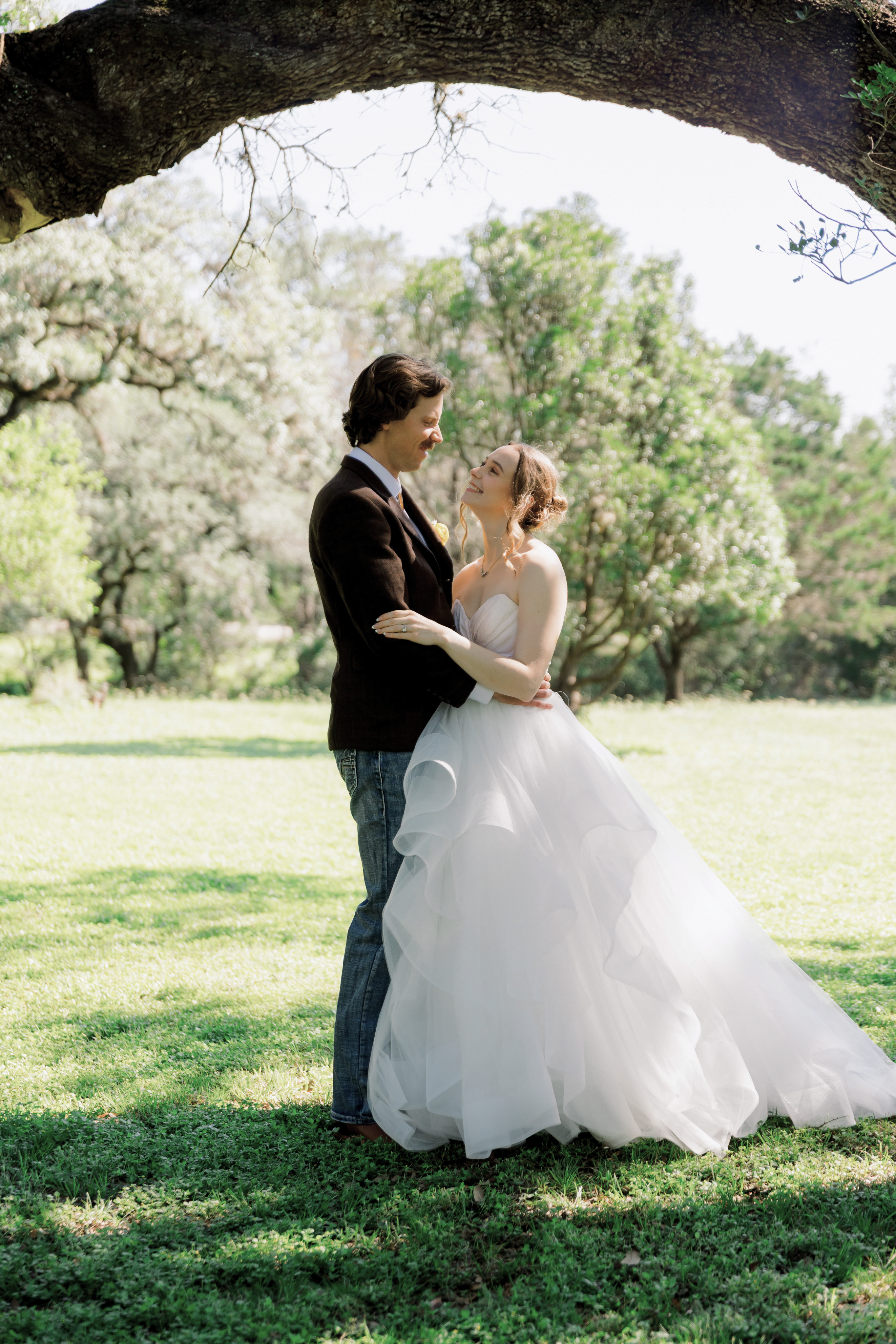 The couple embracing beneath an oak branch