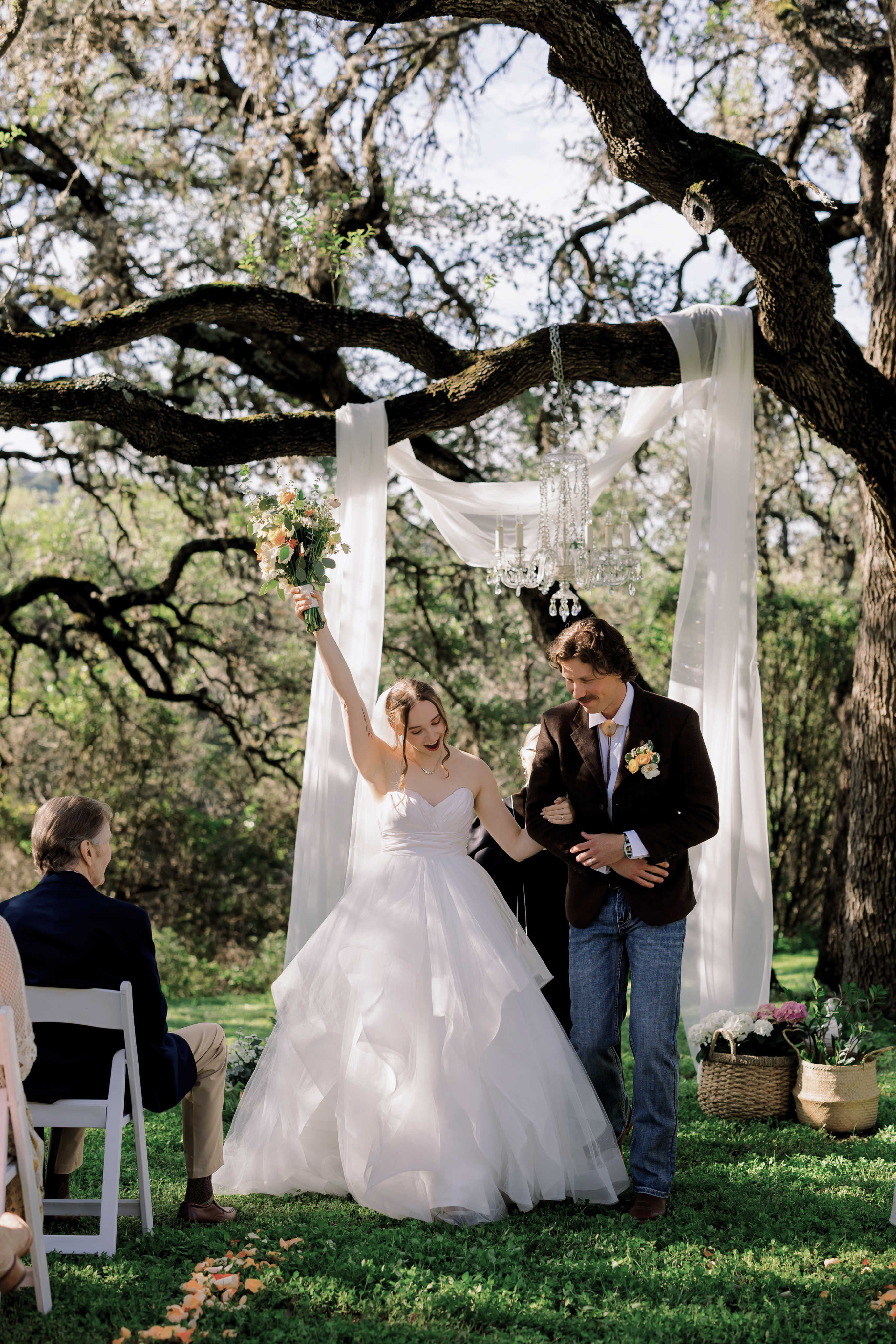 The bride raising her bouquet after the ceremony