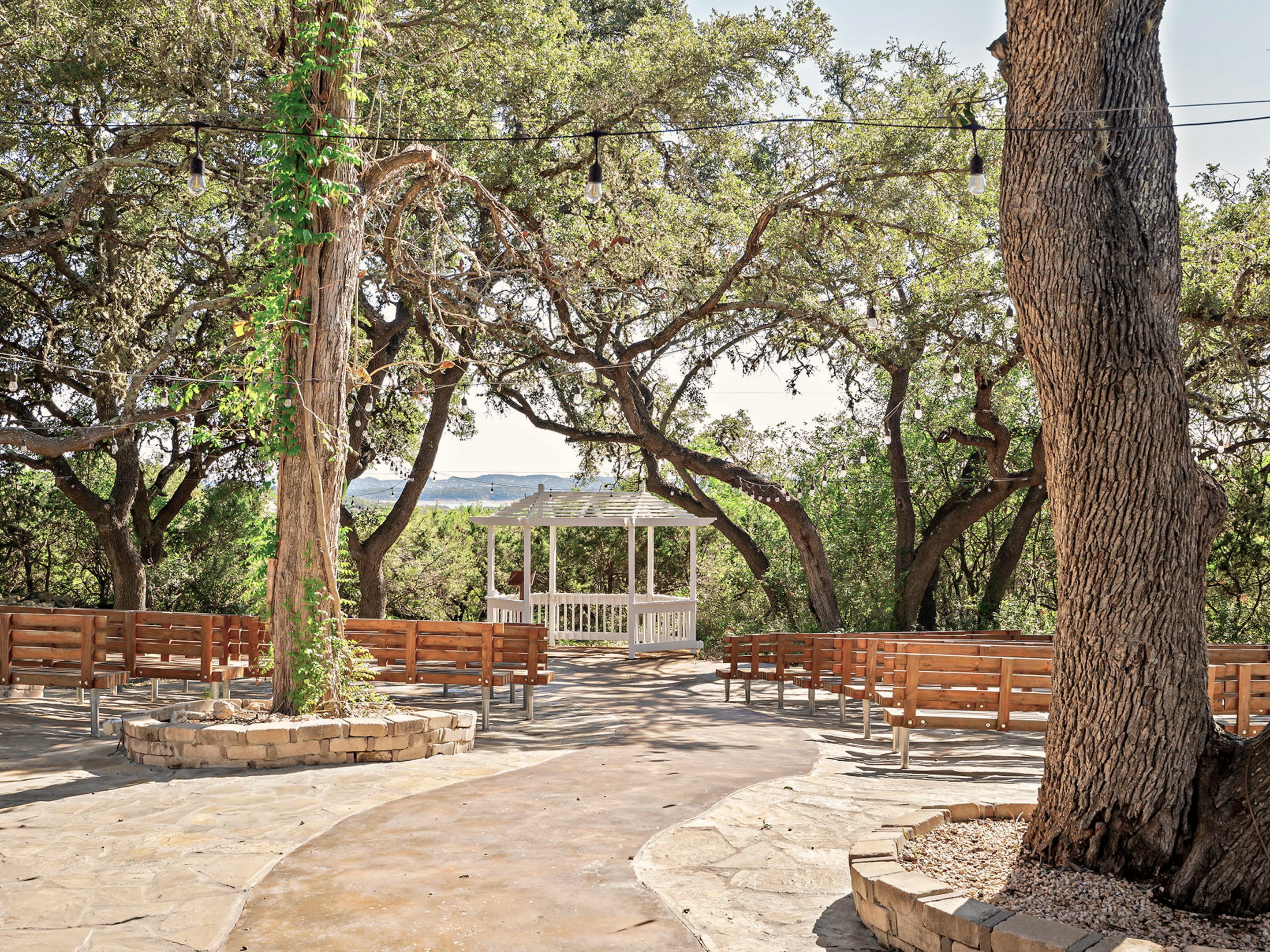 The ceremony space seen through the oaks, the lake visible beyond