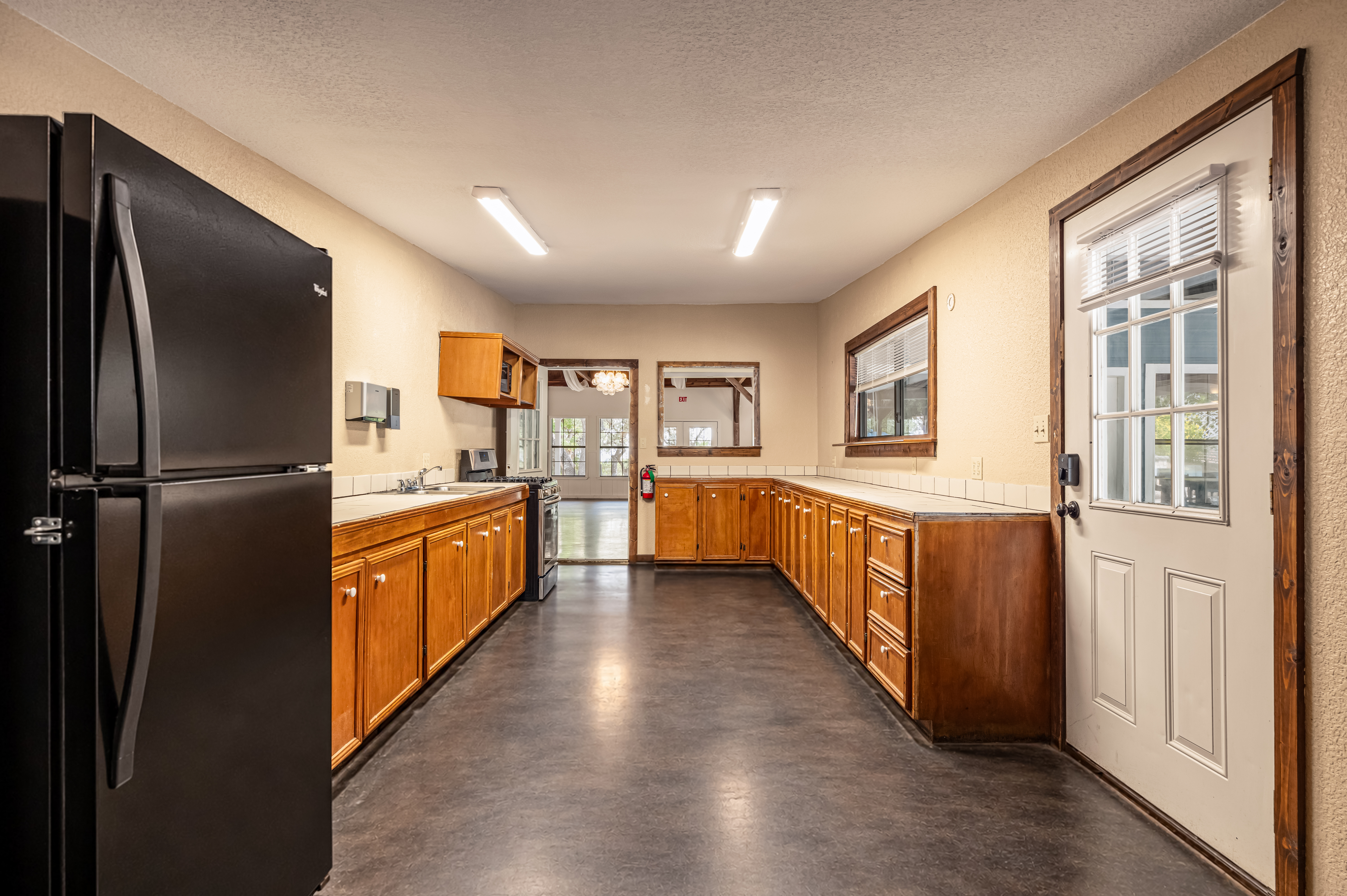 The catering kitchen with fridge, gas range and long counters