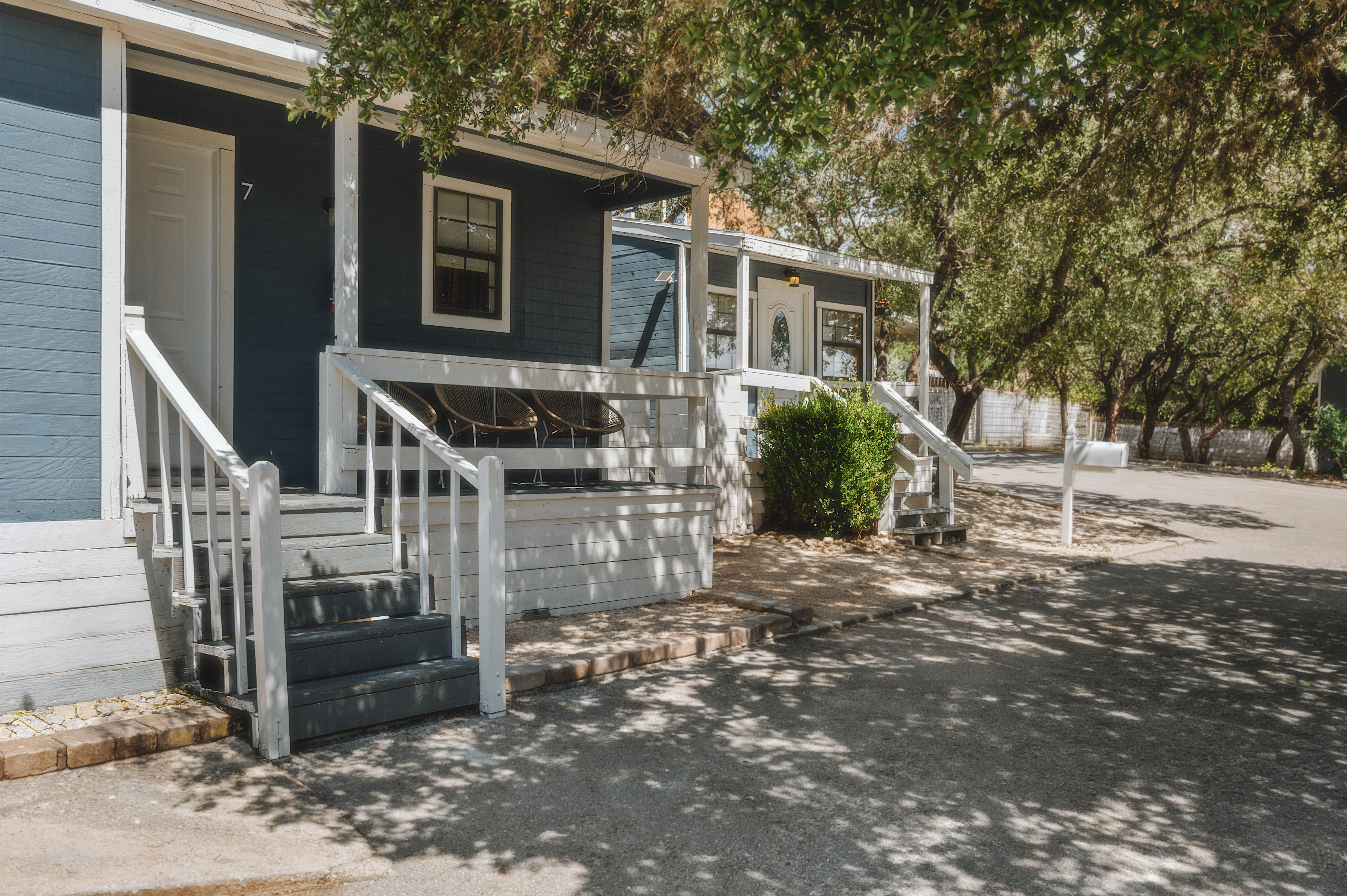 Blue cabins with white porches under the oaks
