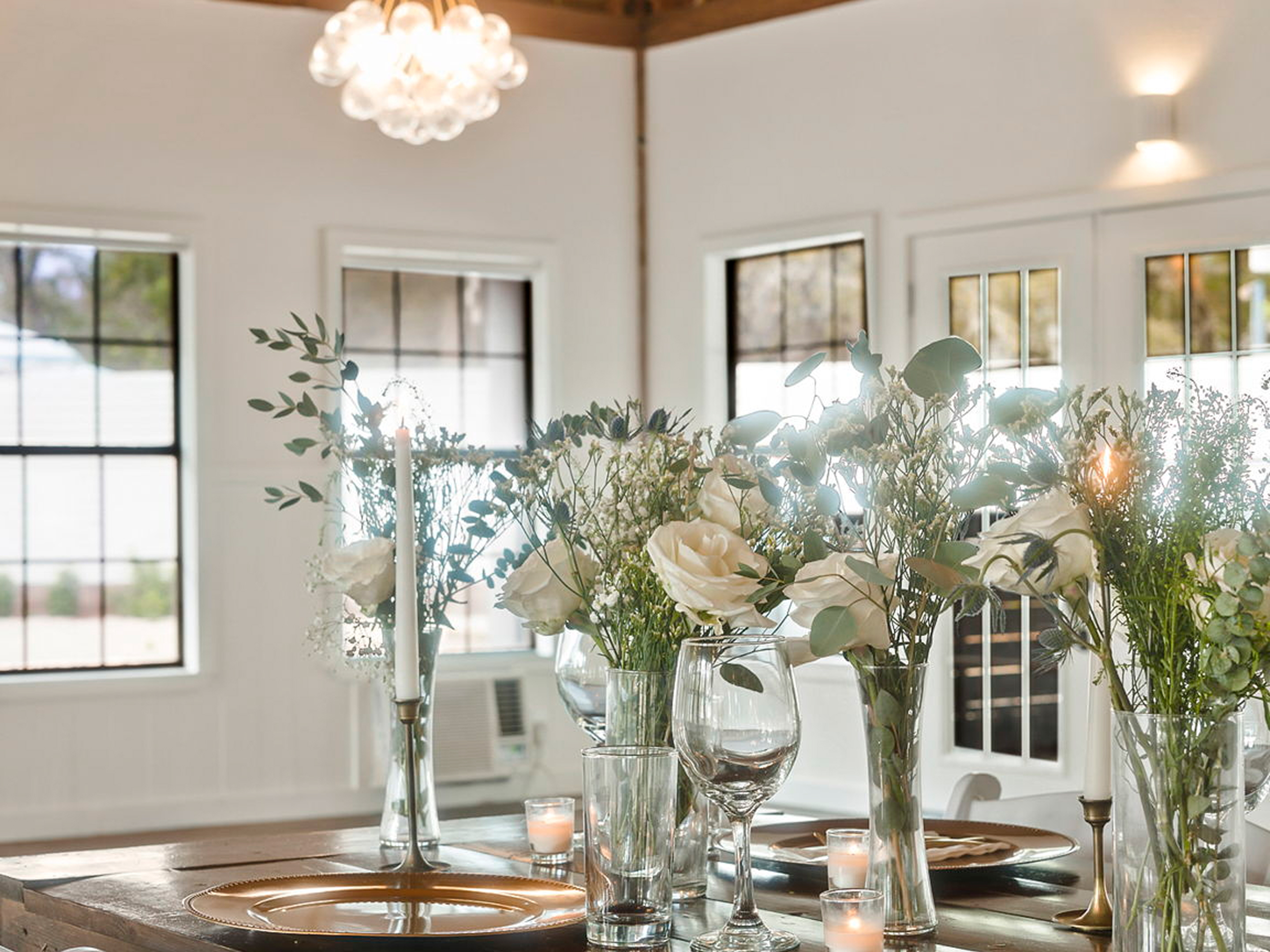 Centerpiece of roses and eucalyptus under a bubble chandelier